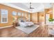 This main bedroom features wood floors, multiple windows, tray ceilings, and an ensuite bathroom at 1123 Barnacle Ter, The Villages, FL 32162