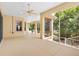 Large, screened lanai featuring multiple ceiling fans and an expansive view of the well-manicured backyard and surrounding trees at 1123 Barnacle Ter, The Villages, FL 32162