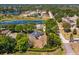 Aerial view of the home with a large lot, surrounded by lush greenery and nearby ponds, highlighting its serene location at 11442 Beggs Ct, Clermont, FL 34711