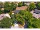 Aerial view of the property showing the home, driveway, mature trees, and outlining the lot's shape in yellow at 11442 Beggs Ct, Clermont, FL 34711