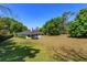 Beautiful backyard with lush green grass, mature trees, and trampoline at 11442 Beggs Ct, Clermont, FL 34711