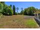 Spacious backyard with a white picket fence and mature trees, offering privacy and a serene outdoor space at 11442 Beggs Ct, Clermont, FL 34711