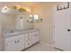 Bathroom featuring double sinks with white cabinets and a large mirror at 11442 Beggs Ct, Clermont, FL 34711