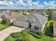 Aerial view of a charming single-Gathering home with a three-car garage and lush landscaping at 1304 Zombar Pl, The Villages, FL 32163