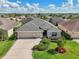 Lovely single-story home with a two-car garage, beautiful landscaping, and a well-manicured lawn in a quiet neighborhood at 1304 Zombar Pl, The Villages, FL 32163