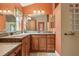 Large bathroom with dual sinks, granite countertops and custom wood cabinetry at 1304 Zombar Pl, The Villages, FL 32163