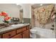 Well-lit bathroom features granite counters, a tub with shower, and coordinated decor at 1304 Zombar Pl, The Villages, FL 32163