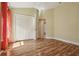 Bright bedroom features hardwood floors, neutral walls, closet, ceiling fan, and an open doorway at 1304 Zombar Pl, The Villages, FL 32163