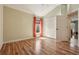 Bright bedroom featuring hardwood floors, closet, and a sunlit window with orange curtains at 1304 Zombar Pl, The Villages, FL 32163