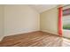 This bedroom features wood floors and a window with an orange curtain at 1304 Zombar Pl, The Villages, FL 32163