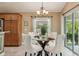 Elegant dining area showcases a glass table, padded chairs, and a stylish chandelier fixture at 1304 Zombar Pl, The Villages, FL 32163