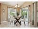 Bright dining area features a glass table, padded chairs, and sliding glass doors for natural light at 1304 Zombar Pl, The Villages, FL 32163