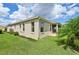 Rear exterior view of the property featuring a screened-in porch and vibrant green lawn at 1304 Zombar Pl, The Villages, FL 32163