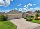 Attractive home exterior with a well-manicured lawn and a spacious three-car garage at 1304 Zombar Pl, The Villages, FL 32163