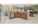 Well-equipped kitchen featuring stainless steel appliances, granite countertops, wooden cabinets, and breakfast table with seating at 1304 Zombar Pl, The Villages, FL 32163