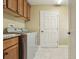 Convenient laundry area featuring front loading machines and overhead cabinet storage at 1304 Zombar Pl, The Villages, FL 32163
