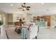 Open-concept living room with a view of the kitchen, comfortable seating, and neutral decor at 1304 Zombar Pl, The Villages, FL 32163