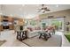 Bright living room with a ceiling fan, tile floors, and view of the kitchen at 1304 Zombar Pl, The Villages, FL 32163