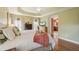 Bright bedroom featuring hardwood floors, tray ceiling, many windows for natural light and stylish decor at 1304 Zombar Pl, The Villages, FL 32163