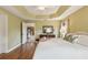 Bright main bedroom with hardwood floors, tray ceiling and an ensuite bathroom at 1304 Zombar Pl, The Villages, FL 32163