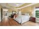 Well-lit main bedroom with hardwood floors, a tray ceiling, and ample storage at 1304 Zombar Pl, The Villages, FL 32163