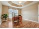 Home office with hardwood floors, a tray ceiling, and lots of natural light at 1304 Zombar Pl, The Villages, FL 32163