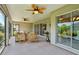 Spacious screened patio with ceiling fans, patio furniture, and sliding glass doors at 1304 Zombar Pl, The Villages, FL 32163