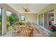 Open-air patio with comfortable wicker seating, ceiling fan, and a view of the landscape at 1304 Zombar Pl, The Villages, FL 32163