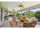 Relaxing screened-in porch with comfortable seating, ceiling fans and a beautiful outdoor view at 1304 Zombar Pl, The Villages, FL 32163