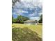 View of the home's backyard, highlighting the expansive lawn, patio, and exterior details at 13430 Sw 105Th Place, Dunnellon, FL 34432