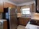 Functional kitchen with stainless steel refrigerator, double sinks, and ample cabinet space at 1485 Morningside Dr, Mount Dora, FL 32757