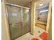 Cozy bathroom with an enclosed glass shower and orange rug accents at 152 Dogwood Trl, Leesburg, FL 34748