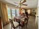 Charming dining area with a large window, decorative ceiling fan, and seating for four at 152 Dogwood Trl, Leesburg, FL 34748