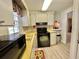 A kitchen offers yellow countertops, white cabinets, and a window with floral curtains at 152 Dogwood Trl, Leesburg, FL 34748