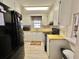 Traditional kitchen featuring white cabinetry, yellow countertops, black appliances, and a window with floral valance at 152 Dogwood Trl, Leesburg, FL 34748