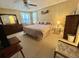 Spacious main bedroom with a large bed, ceiling fan, dresser, and two windows at 152 Dogwood Trl, Leesburg, FL 34748