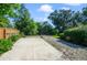 Large backyard with a concrete patio, green bushes, and mature trees, ready for outdoor enjoyment at 15935 J And J Dr, Tavares, FL 32778