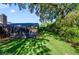 Green backyard with a screened-in patio and pool, partially shaded by mature trees, offering a private retreat at 15935 J And J Dr, Tavares, FL 32778