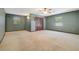 Large carpeted bedroom with neutral walls, two windows, ceiling fan, closet, and plenty of space at 15935 J And J Dr, Tavares, FL 32778