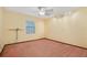 Spacious bedroom with yellow walls, pink carpet, ceiling fan and natural light from the window at 15935 J And J Dr, Tavares, FL 32778