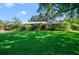Charming single-story brick home with a manicured lawn and mature landscaping including palm trees at 15935 J And J Dr, Tavares, FL 32778