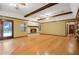 Open living room boasts hardwood floors, brick fireplace, wood beam ceilings, and a french door at 15935 J And J Dr, Tavares, FL 32778