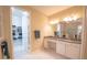 Bathroom featuring double vanity with granite countertop, white cabinets, and open closet space at 179 Birchmont Dr, Deland, FL 32724