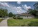Charming home with well-manicured lawn, a curved driveway, and lush green landscaping at 179 Birchmont Dr, Deland, FL 32724