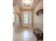 Bright foyer with white tile flooring, a coat rack, and a view of the main entryway door at 179 Birchmont Dr, Deland, FL 32724
