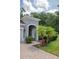Charming front yard with well-maintained landscaping, palm trees, and brick-paved walkway to the house at 179 Birchmont Dr, Deland, FL 32724