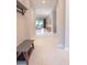Spacious hallway with white tile flooring leading into the home and a furniture bench at 179 Birchmont Dr, Deland, FL 32724