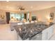 Open-concept kitchen featuring marble countertops and stainless steel appliances with a view of the living room at 179 Birchmont Dr, Deland, FL 32724