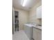 Laundry room with tile floors, modern washer and dryer, utility sink and storage shelves at 179 Birchmont Dr, Deland, FL 32724