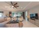 Comfortable living room featuring a plush sofa, stylish chairs, and a large ceiling fan at 179 Birchmont Dr, Deland, FL 32724